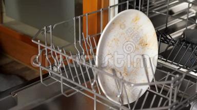 人们把脏盘子和餐具放进洗碗机的特写镜头